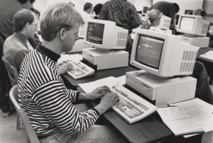 People use old-fashioned computers in a computer lab.