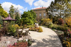 A beautiful large garden with an old stone building in the background.