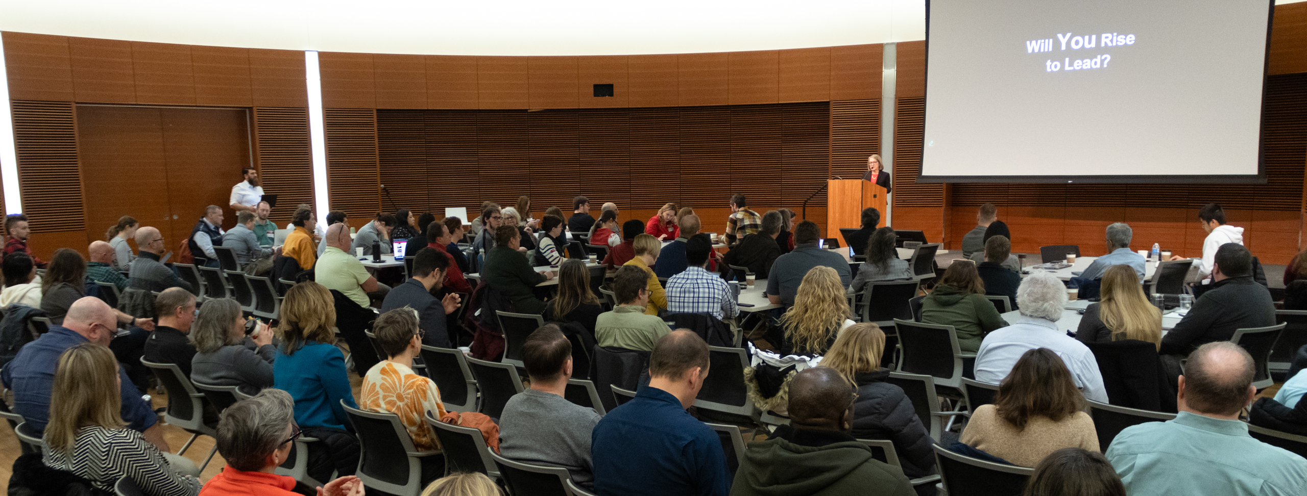 Laura Patterson speaks to a large seated audience.
