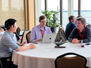 3 IT professionals sit around a round table and talk at the 2025 IT Professionals Conference.