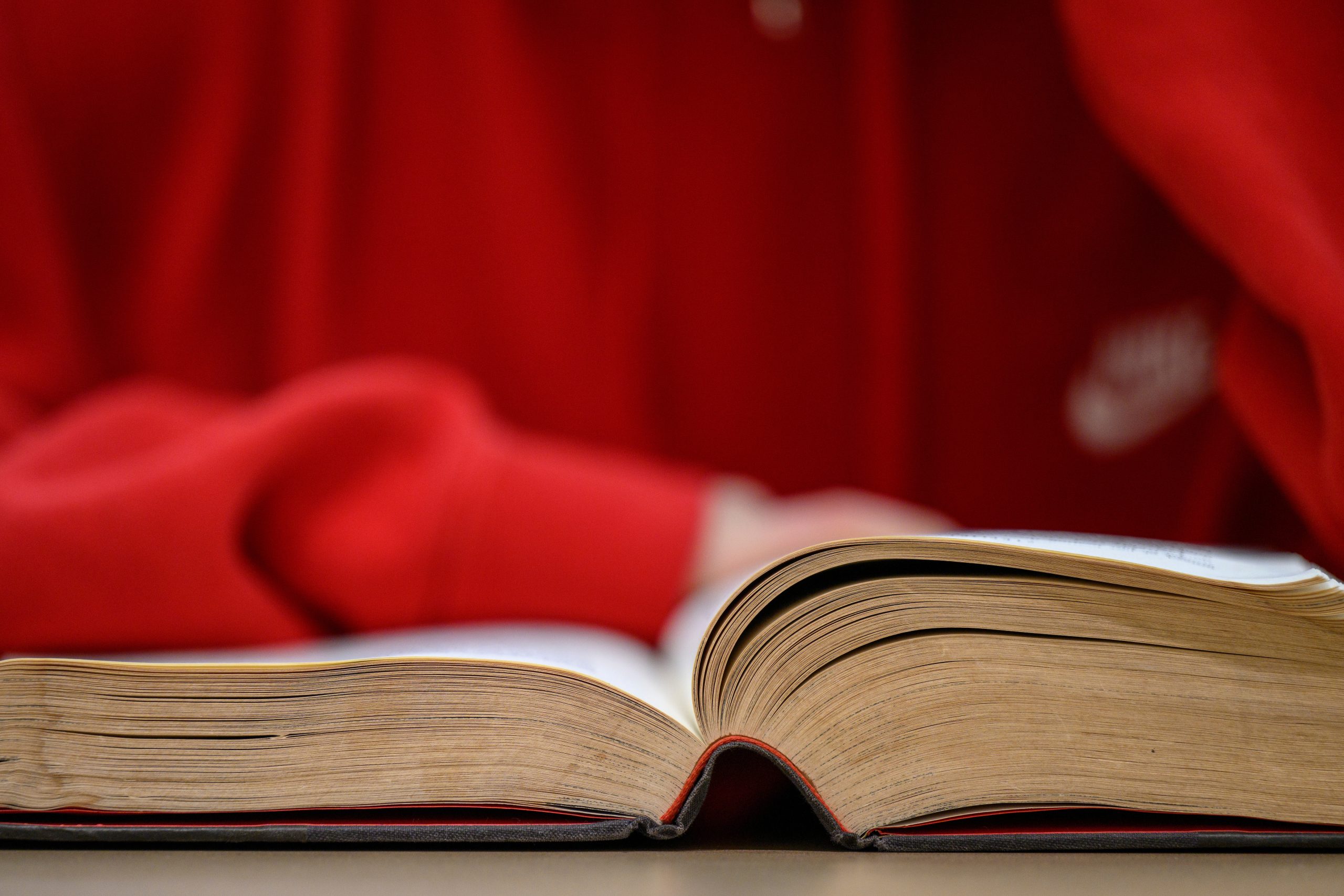 A student wearing red reads a book